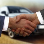 Car dealer shaking hands